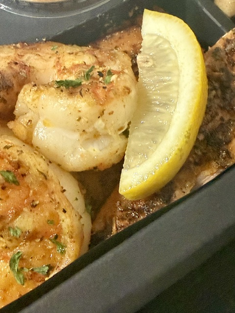 Seasoned shrimp and fish with a lemon wedge